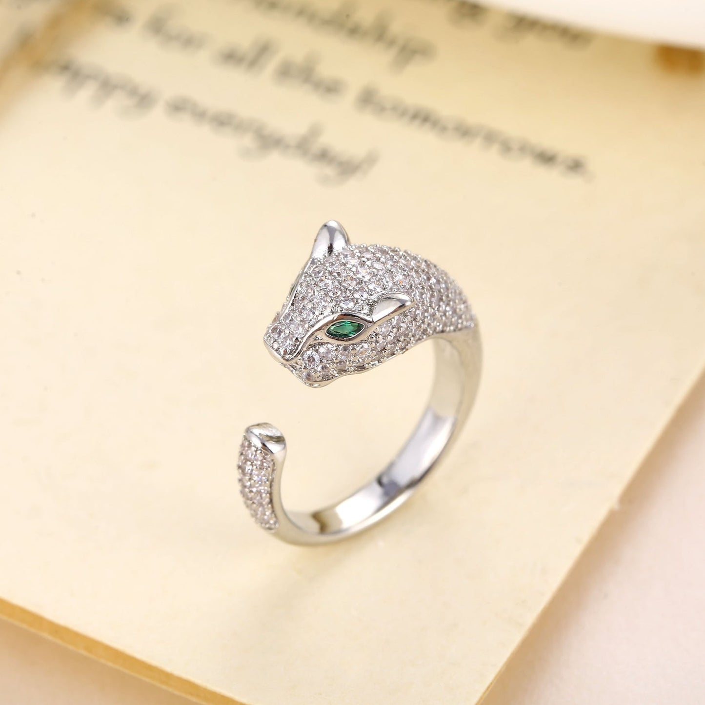 Silver tone tiger ring with green gemstone eyes and clear pavé stones.