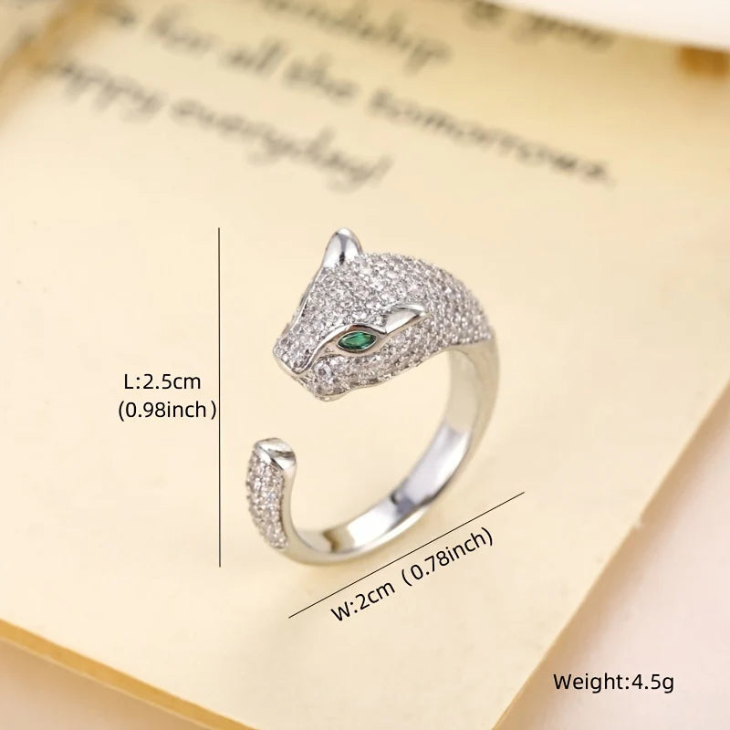 Silver tiger head ring with green eyes and clear stone accents. Stylish animal-themed jewelry.