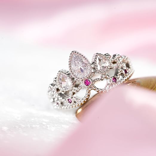 Silver crown ring with pear-shaped and round white and pink gemstones.