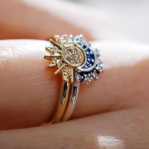 Sun and Moon ring set on finger, celestial jewelry detail.
