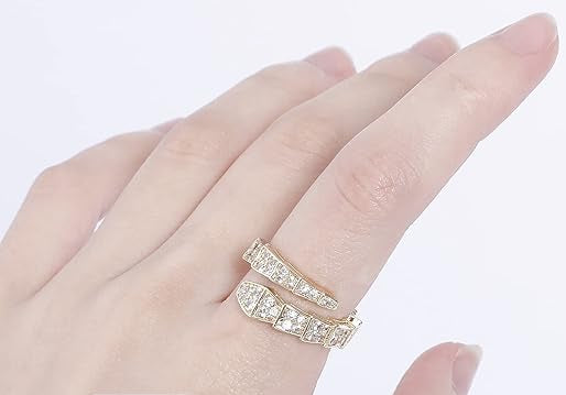 Hand wearing a gold spiral ring with diamond accents.