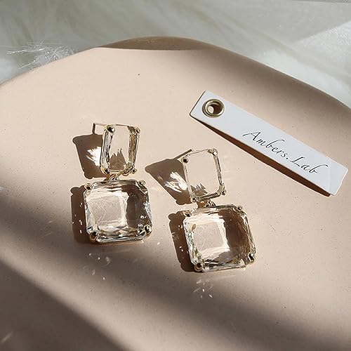 Amber's Lab crystal drop earrings featuring square clear stones and gold settings.
