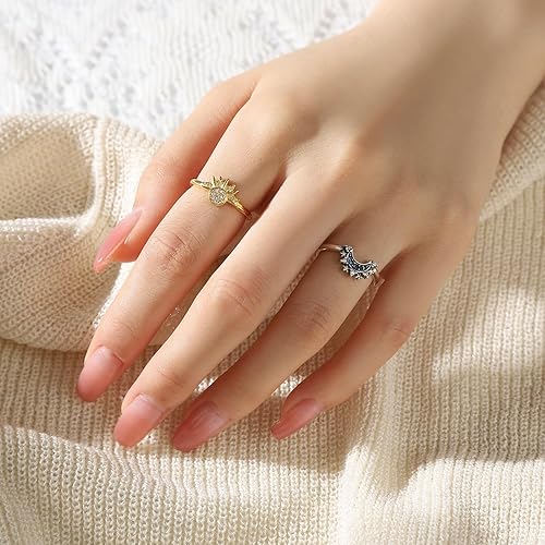 Hand showcasing a gold sunflower ring and a silver tiara ring against a cream sweater.