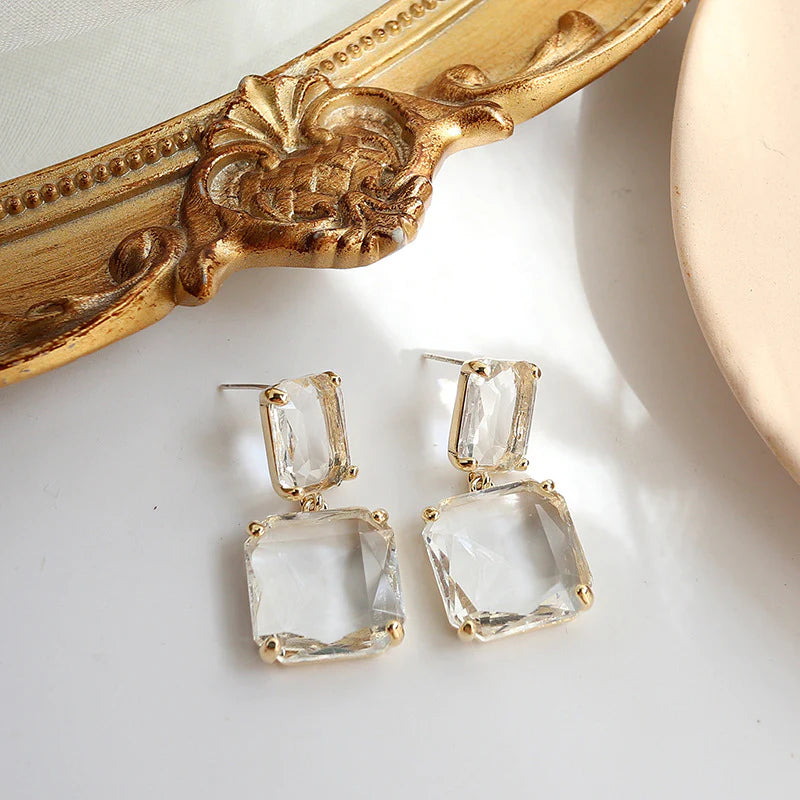 Elegant clear quartz drop earrings with gold settings, a stylish jewelry accessory.