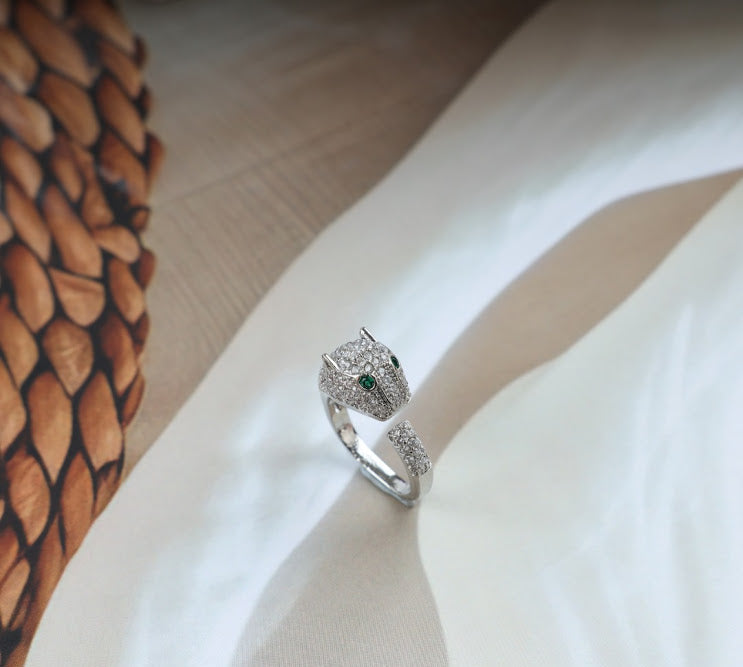 Silver tiger ring with green eyes and diamond accents.