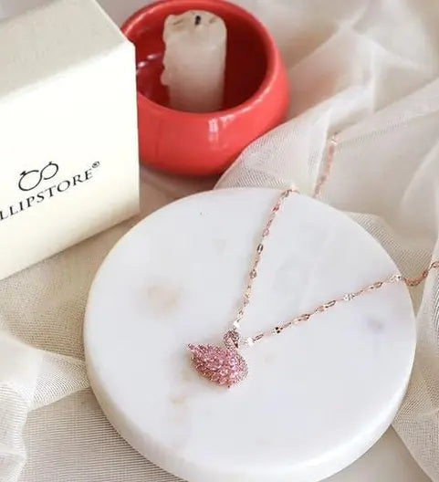 Rose gold necklace featuring a pink crystal swan pendant.