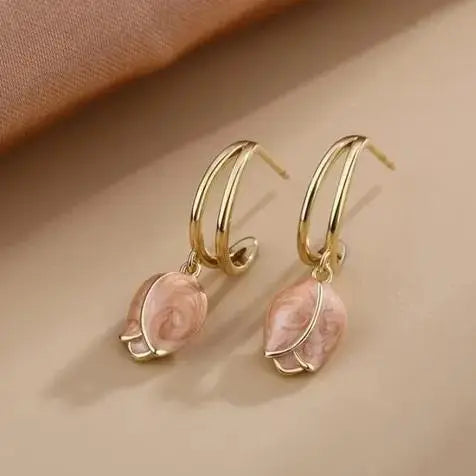 Gold hoop earrings with pink tulip-shaped charms.