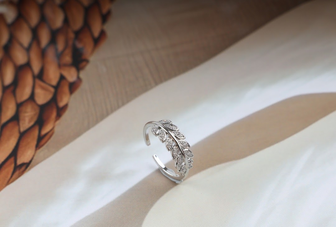 Silver leaf ring with crystal accents, adjustable band.