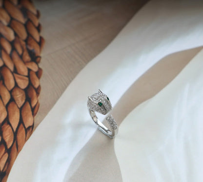Silver tiger ring with green eyes and diamond accents.