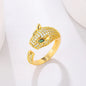 Gold ring featuring a jaguar head design, adorned with cubic zirconia and green stone eyes.